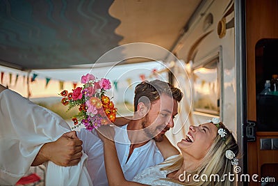 close up of a young beardy man carrying his bride inside of the camper, smiling, laughing Stock Photo