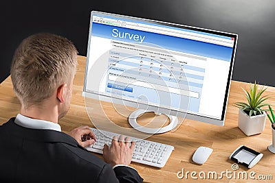 Businessman Filling Online Survey Form On Computer Stock Photo