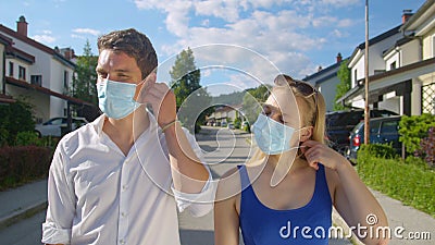 CLOSE UP Young couple takes off their protective facemasks after end of covid-19 Stock Photo