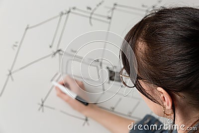 Close-up of a young female architect drawing a sketch for a new famaly home project. Concept of work on technical drawings Stock Photo