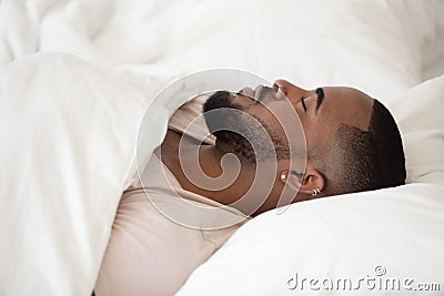 Close up young black man sleeping in bed. Stock Photo