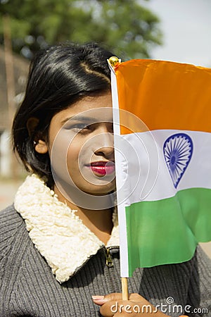 Close-up of young Indian girl holding Indian National flag covering half her face, Pune Stock Photo