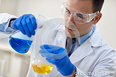 close up of young male scientist with flask making test or research. Stock Photo