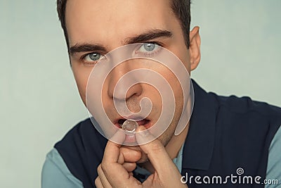 Close - up of a young man with a tablet in his hands to freshen his breath Stock Photo