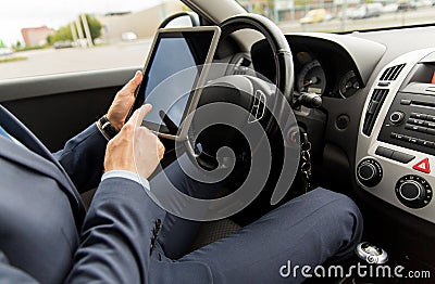 Close up of young man with tablet pc driving car Stock Photo