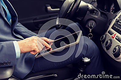 Close up of young man with tablet pc driving car Stock Photo