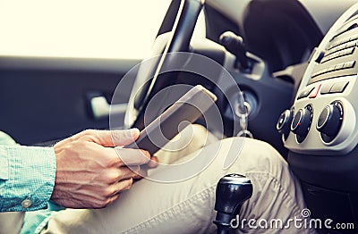 Close up of young man with tablet pc driving car Stock Photo