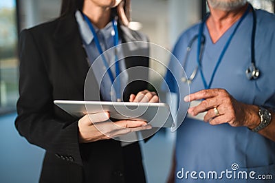 Close-up of young pharmaceutic seller explaining something to doctor in hospital. Stock Photo