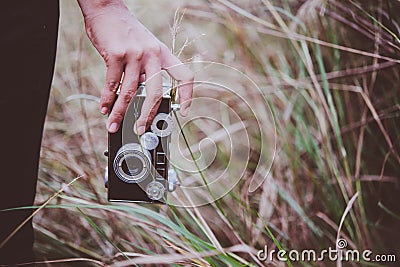 Close up of young woman hand holding retro camera walk through i Stock Photo