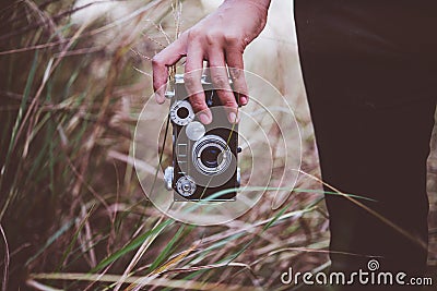 Close up of young woman hand holding retro camera walk through i Stock Photo