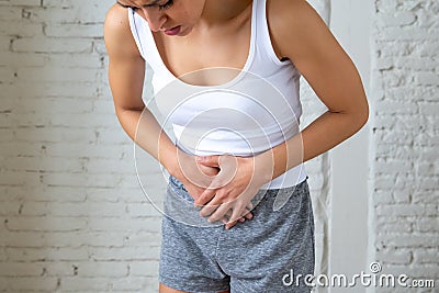 Close up of beautiful woman body suffering from stomachache, period pain and menstrual cramps Stock Photo