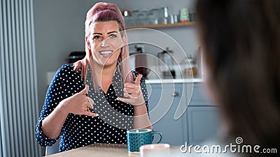 Close UpOf Woman Having Conversation At Home Using Sign Language Stock Photo