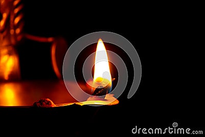 Close view of lit diya lamp against dark background. Lamp made out of silver metal lit during festival Stock Photo