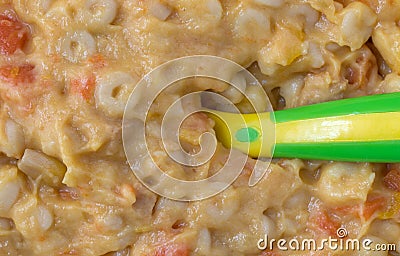 Close view of macaroni and cheese baby food with a spoon in the food Stock Photo