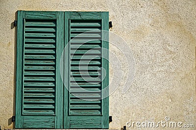 Close vintage window shutter in sunny day, italy style concrete cement wall Stock Photo