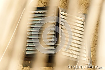 Close window behind a rusty fence. Grunge architecture design Stock Photo