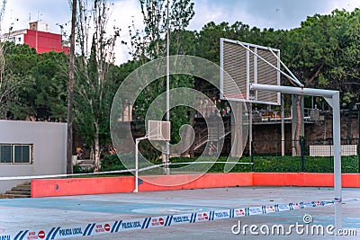 Closed basketball field at the park. Local police restriction tapes around empty field due to COVID-19 pandemic Editorial Stock Photo