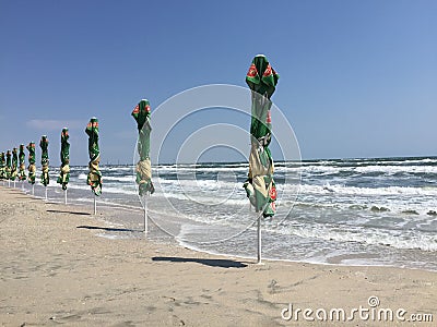 Closed beach umbrellas due strong wind Editorial Stock Photo