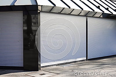 Closed business shop or store front with roller shutters Stock Photo