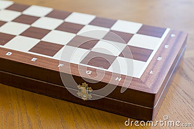 Closed checkerboard close-up. Closed chessboard for chess game on wooden table Stock Photo