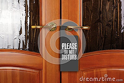 Closed door with sign PLEASE DO NOT DISTURB on handle at hotel Stock Photo