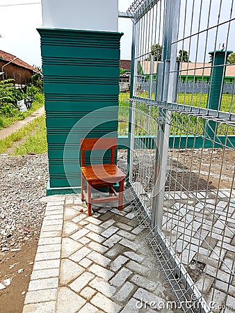 the closed entrance gate and the empty guard seat Stock Photo
