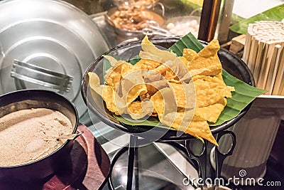 Closed fried wonton wrapper on banana leaf for noodle topping at Stock Photo