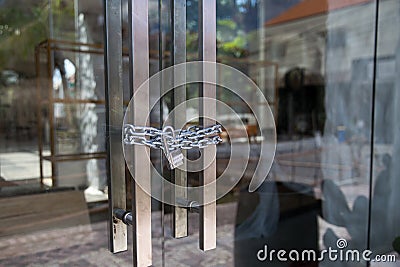 Closed glass door with mettalic chain Stock Photo