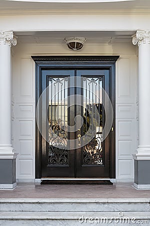 Closed Glossy Black and Glass Front Doors of an Upscale Home Stock Photo