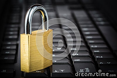 Closed golden padlock on a black keyboard Stock Photo