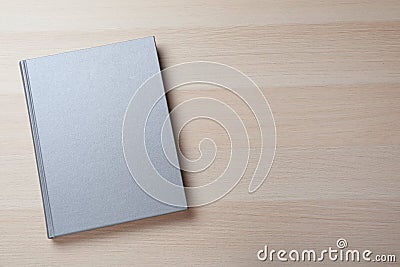 Closed grey book with hard cover on wooden table, top view. Space for text Stock Photo