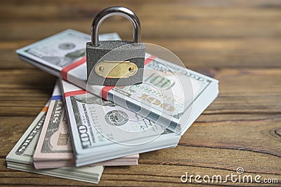 Closed lock and a stack of dollars of banknotes. Stock Photo
