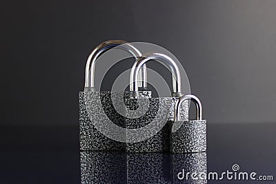 Closed padlocks on a dark background. Mirror reflection of closed locks. Dark background Stock Photo