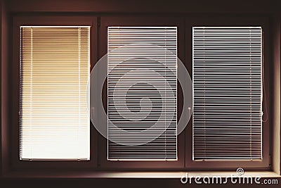 Closed plastic window on sunny day with horizontal plastic blinds Stock Photo