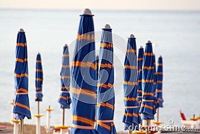 Closed umbrellas on the beach Stock Photo