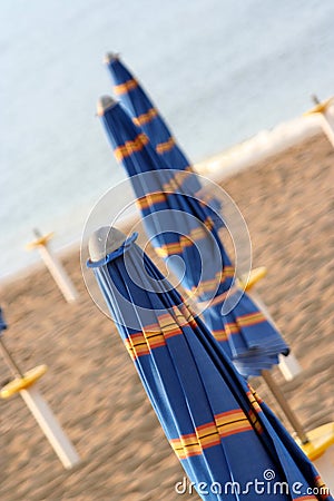 Closed umbrellas on the beach Stock Photo