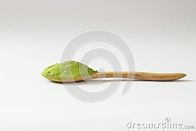 Closed up isolate heap of extract Green Tea powder in wooden sp Stock Photo