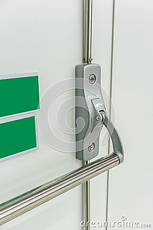 Closed up latch and door handle of emergency exit. Push bar and rail for exit Stock Photo