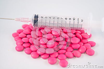 Closed up pink tablet and disposable syringe Stock Photo