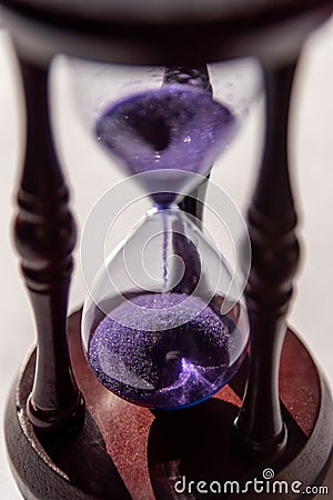 Closed up of sandglass or hourglass with violet, purple sand Stock Photo