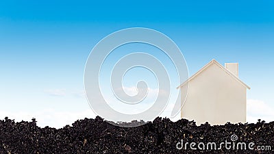 Closed up tiny toy wooden house model on ground with blue sky background, concept of growth, real estate, investments for the Stock Photo