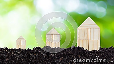 Closed up tiny toy wooden house model on ground with sunlight bokeh background, concept of growth, real estate, investments for Stock Photo