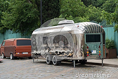 Retro style futuristic silver metal trailer van standing on summer day for fair, festival or event. Editorial Stock Photo