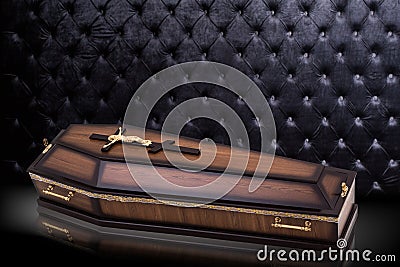 Closed wooden brown coffin with Church cross on gray luxury background. casket on royal background. Stock Photo