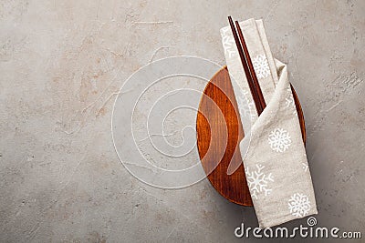 Closed wooden Japanese lunchbox with chopsticks, wrapped in a festive cloth on an old stone table. Top view with copy Stock Photo