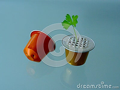 Closeup abstract of spent aluminum coffee capsules to be recycled with green leaf. metaphor Stock Photo