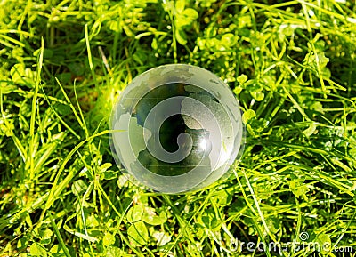 Closeup of an Acrylic Crystal Ball with the world map on the grass Stock Photo