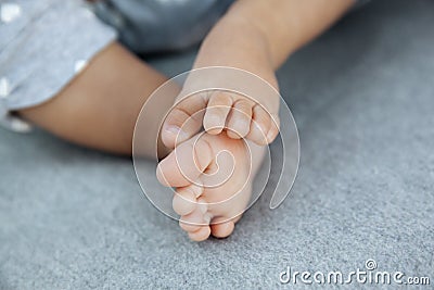 Closeup of adorable baby feet and tiny toes on soft grey blanket as a background Stock Photo