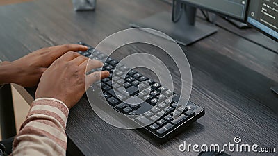Closeup of african american programer hands typing code on keyboard while looking at computer screens Stock Photo