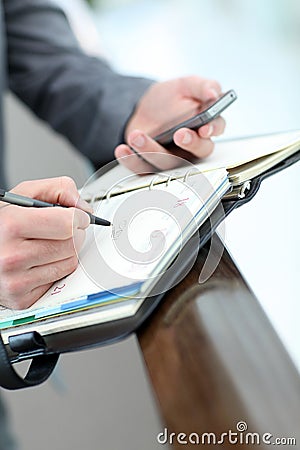 Closeup of agenda and smartphone in man's hands Stock Photo